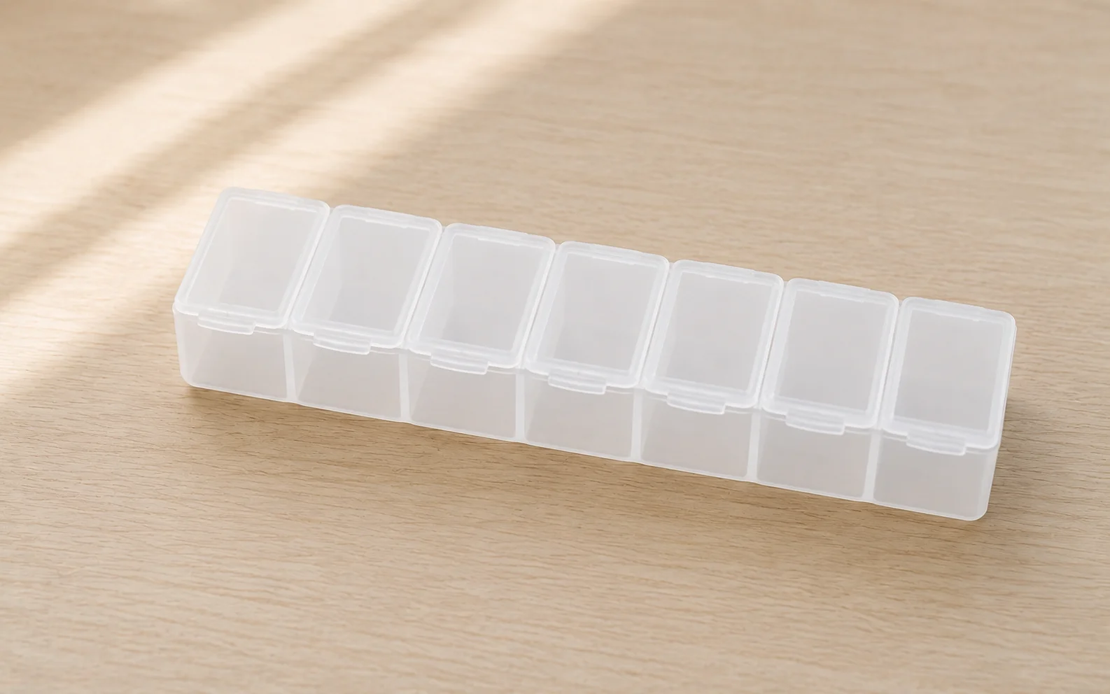 An empty seven-compartment weekly organizer on a clean light surface