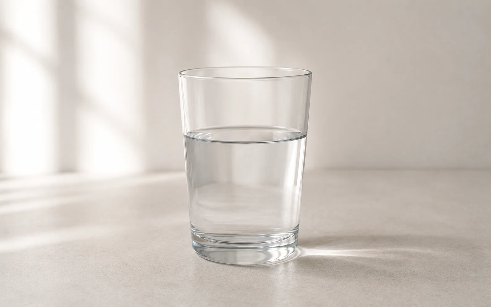 A clear glass of water filled to a steady level on a clean surface