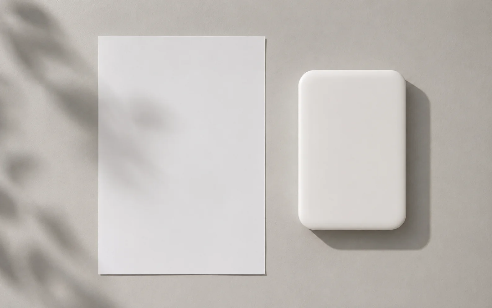 A plain unbranded tablet beside a blank document on a calm neutral surface