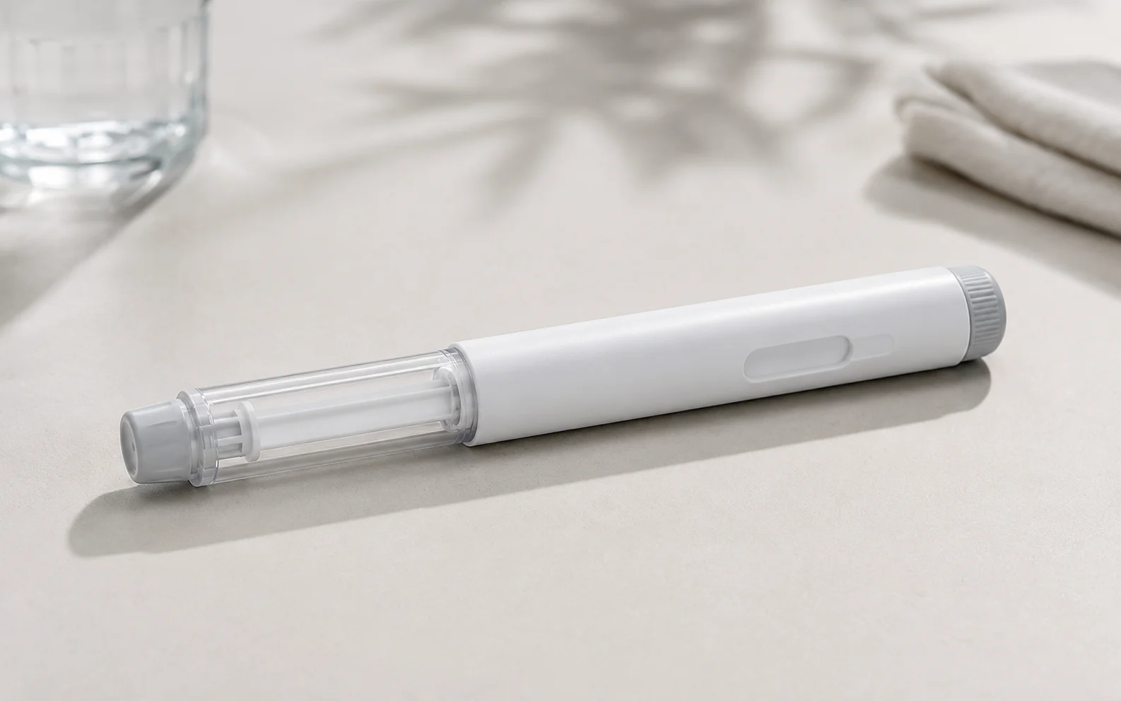 A plain unbranded medical injector pen on a clean neutral surface