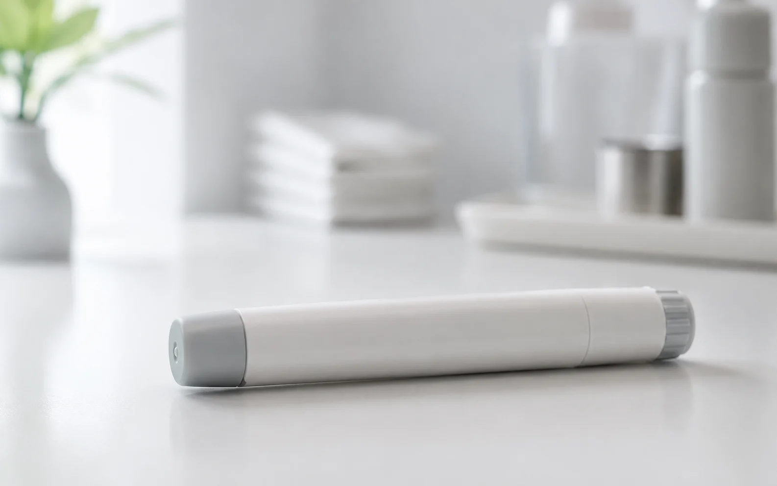 A plain unbranded medical injector pen resting on a clean clinical surface