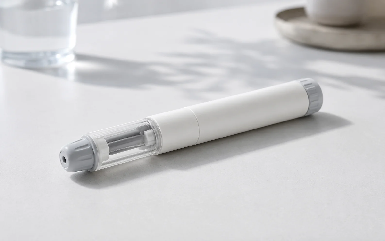 A plain unbranded medical injector pen resting on a clean clinical surface
