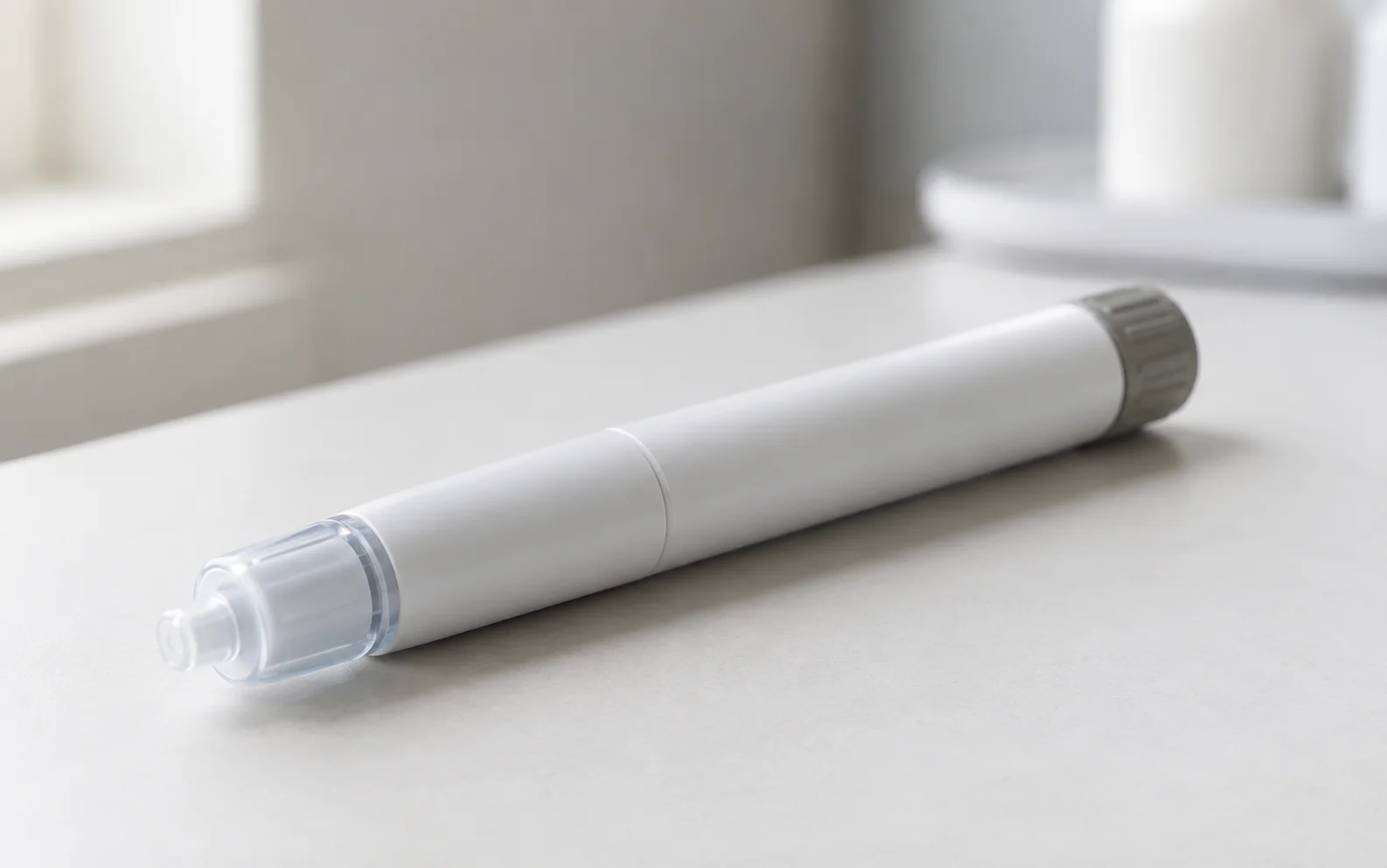 A plain unbranded medical injector pen resting on a clean clinical surface