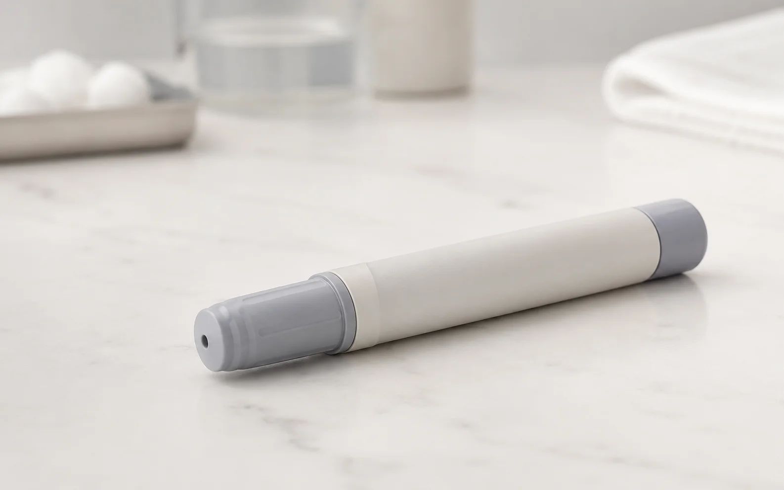 A plain unbranded medical injector pen resting on a clean clinical surface